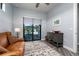 Comfortable living room featuring a leather sofa and sliding glass doors to backyard patio at 15691 Meacham Cir, Port Charlotte, FL 33981