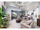 Spacious living room features tray ceilings, ceiling fan, and sliding glass doors to the outdoor lanai and pool at 15691 Meacham Cir, Port Charlotte, FL 33981