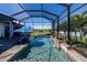 Stunning screened-in pool area with waterfalls, lounge chairs, and lush tropical landscaping at 15691 Meacham Cir, Port Charlotte, FL 33981