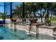 Beautiful pool with cascading water features, lush landscaping, and a screened enclosure at 15691 Meacham Cir, Port Charlotte, FL 33981