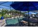 Screened-in pool with water features, patio furniture, and manicured landscaping at 15691 Meacham Cir, Port Charlotte, FL 33981
