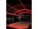 Screened pool glows red at night with pond and landscape views at 170 Long Meadow Ln, Rotonda West, FL 33947