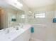 Bathroom featuring dual sinks, a large mirror, and a glass-enclosed shower at 209 Malina Ct, Nokomis, FL 34275