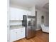 Modern kitchen with white cabinets, granite countertops, and stainless steel refrigerator at 209 Malina Ct, Nokomis, FL 34275