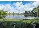 Breathtaking view of the lake from the screened-in patio, with bird baths and palm trees enhancing the scenery at 209 Malina Ct, Nokomis, FL 34275