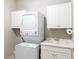 Bright laundry room with a stackable washer/dryer and white cabinets at 209 Malina Ct, Nokomis, FL 34275
