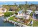 Aerial view of property on waterfront with boat lift, lush landscaping and in-ground pool at 295 North Dr, Englewood, FL 34223