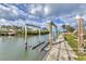 Image shows a dock with a boat lift on a canal with lush greenery and palm trees at 295 North Dr, Englewood, FL 34223