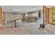 Spacious garage with exposed ceiling, open doors, workbench and wiring at 295 North Dr, Englewood, FL 34223