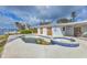 A stunning pool and spa with a waterfront view, surrounded by tropical plants at 295 North Dr, Englewood, FL 34223