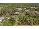 Aerial view of a home with a screened-in pool, surrounded by lush greenery and mature trees in a tranquil setting at 3892 Alwood St, North Port, FL 34291