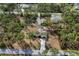 Aerial view of single-story home with a long driveway and surrounded by lush trees at 3892 Alwood St, North Port, FL 34291