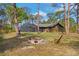 Backyard with a screened-in porch, a fire pit with chairs, and a view of the home at 3892 Alwood St, North Port, FL 34291