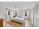 Airy main bedroom features bright walls, a modern bed frame, hardwood floors and three large windows at 3892 Alwood St, North Port, FL 34291