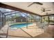 The enclosed pool area includes a pool, ceiling fans, and a dining table at 3892 Alwood St, North Port, FL 34291