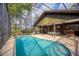 Screened-in pool with a lounge chair and a dining area, perfect for relaxation at 3892 Alwood St, North Port, FL 34291
