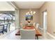 Dining room with a wood table, modern light fixture, and sliding glass doors to the lanai at 8200 Antwerp Cir, Port Charlotte, FL 33981