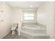 Bathroom featuring a jacuzzi tub, toilet and window at 1003 Old Englewood Rd, Englewood, FL 34223