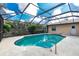 Beautiful in-ground pool surrounded by a screened-in lanai and lush greenery at 1003 Old Englewood Rd, Englewood, FL 34223