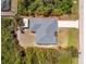 Aerial view shows a single-story house with a detached storage shed and a long driveway surrounded by lush, green trees at 11453 Oceanspray Blvd, Englewood, FL 34224