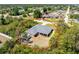 Aerial view of a charming single-story home with a detached storage shed and screened lanai surrounded by lush trees at 11453 Oceanspray Blvd, Englewood, FL 34224