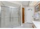 Bathroom featuring a glass-enclosed shower, tiled floors, and a door to the outside at 11453 Oceanspray Blvd, Englewood, FL 34224