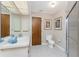 Bathroom showcasing a tiled floor, toilet, and a sink with a large mirror at 11453 Oceanspray Blvd, Englewood, FL 34224