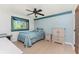 Bedroom with light blue walls and an accent border, fan, window, and neutral-toned furniture at 11453 Oceanspray Blvd, Englewood, FL 34224