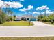 Charming single-story home with a well-manicured lawn and a turquoise garage door at 11453 Oceanspray Blvd, Englewood, FL 34224