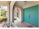Inviting front entrance with double turquoise doors, arched entrance, and tiled porch at 11453 Oceanspray Blvd, Englewood, FL 34224