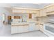 Charming kitchen features white cabinets and views to the living area at 11453 Oceanspray Blvd, Englewood, FL 34224