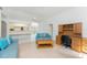 Living room with neutral paint, wood floors, ceiling fan, and built-in cabinets near an adjacent eat-in kitchen at 11453 Oceanspray Blvd, Englewood, FL 34224