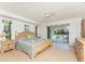 Spacious main bedroom with light wood floors, natural light, access to the back yard, and light-colored walls at 11453 Oceanspray Blvd, Englewood, FL 34224