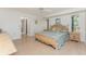 Spacious main bedroom with light wood floors, natural light, a ceiling fan, and an en-suite bathroom at 11453 Oceanspray Blvd, Englewood, FL 34224