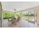 Relaxing screened lanai featuring comfortable seating and serene views of the backyard landscaping at 11453 Oceanspray Blvd, Englewood, FL 34224