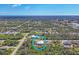 Expansive aerial view of a serene community nestled among lush trees, with scattered homes and winding roads at 12028 Newgate Ave, Port Charlotte, FL 33981