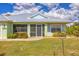 Charming home featuring a screened entry and a bright exterior, complemented by a beautifully maintained green lawn at 12028 Newgate Ave, Port Charlotte, FL 33981