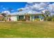 Charming single Gathering home showcasing a beautiful metal roof, fresh green paint, and manicured lawn at 12028 Newgate Ave, Port Charlotte, FL 33981