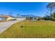 Inviting single-story home with a manicured lawn and a spacious driveway leading to the garage at 12028 Newgate Ave, Port Charlotte, FL 33981