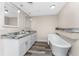 Bathroom featuring a soaking tub, double sink vanity with granite counters and wood-look flooring at 1313 Buereau Rd, Englewood, FL 34223