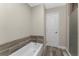 Bathroom with soaking tub, shower with glass doors, and stylish wood-look flooring at 1313 Buereau Rd, Englewood, FL 34223