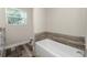 Bathroom with a modern vanity, soaking tub, and stylish wood-look flooring at 1313 Buereau Rd, Englewood, FL 34223