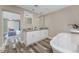 Bathroom featuring a soaking tub, double sink vanity with granite counters and wood-look flooring at 1313 Buereau Rd, Englewood, FL 34223