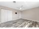 Spacious bedroom with weathered wood flooring, ceiling fan, closet and TV mount at 1313 Buereau Rd, Englewood, FL 34223