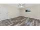 Bedroom featuring weathered wood flooring, ceiling fan, window, and doors at 1313 Buereau Rd, Englewood, FL 34223