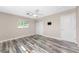 Bedroom with weathered wood flooring, ceiling fan, window, closet, and TV mount at 1313 Buereau Rd, Englewood, FL 34223
