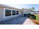 Charming home entrance with a paved walkway, garden, and a large window reflecting a well-manicured lawn at 1313 Buereau Rd, Englewood, FL 34223