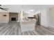 Bright open-concept kitchen and dining area with island and modern appliances overlooking the living room with fireplace at 1313 Buereau Rd, Englewood, FL 34223