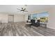 Bright and spacious living room with a ceiling fan, large windows, and wood-look flooring at 1313 Buereau Rd, Englewood, FL 34223