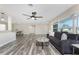 Open-concept living room and dining area with modern ceiling fan and wood-look flooring at 1313 Buereau Rd, Englewood, FL 34223